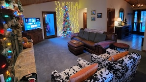 A cozy living room with a fireplace, a Christmas tree, and a television. - Four Seasons Getaway-Private Spa-Walk to Village and Pineknot Trailhead-King Bed (Big Bear Lake)