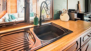 Una cocina con un lavamanos, un hervidor y una cafetera.