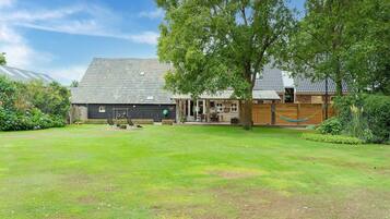 Relax in a serene backyard with a well-maintained lawn and comfortable seating areas.