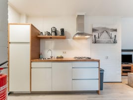 Una cocina compacta con estufa integrada, un lavamanos y una encimera de madera.