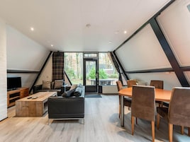 Un moderno apartamento tipo loft con comedor, sofá y televisor.