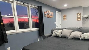 A bedroom with a bed, a window with curtains, a door, and wall decorations. - Mankato’s Safe Haven (Mankato)