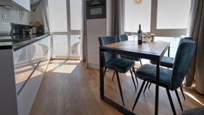 A modern kitchen with a dining area, large windows, and a view of the sea. - Apartment in Scherpenisse by Oosterschelde (Scherpenisse)