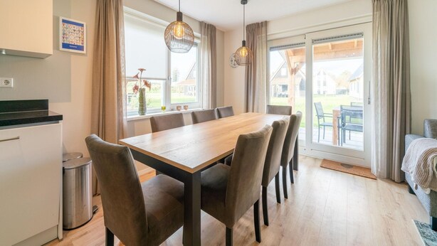 Una cucina moderna con zona pranzo, ampie finestre e vista sull'esterno.