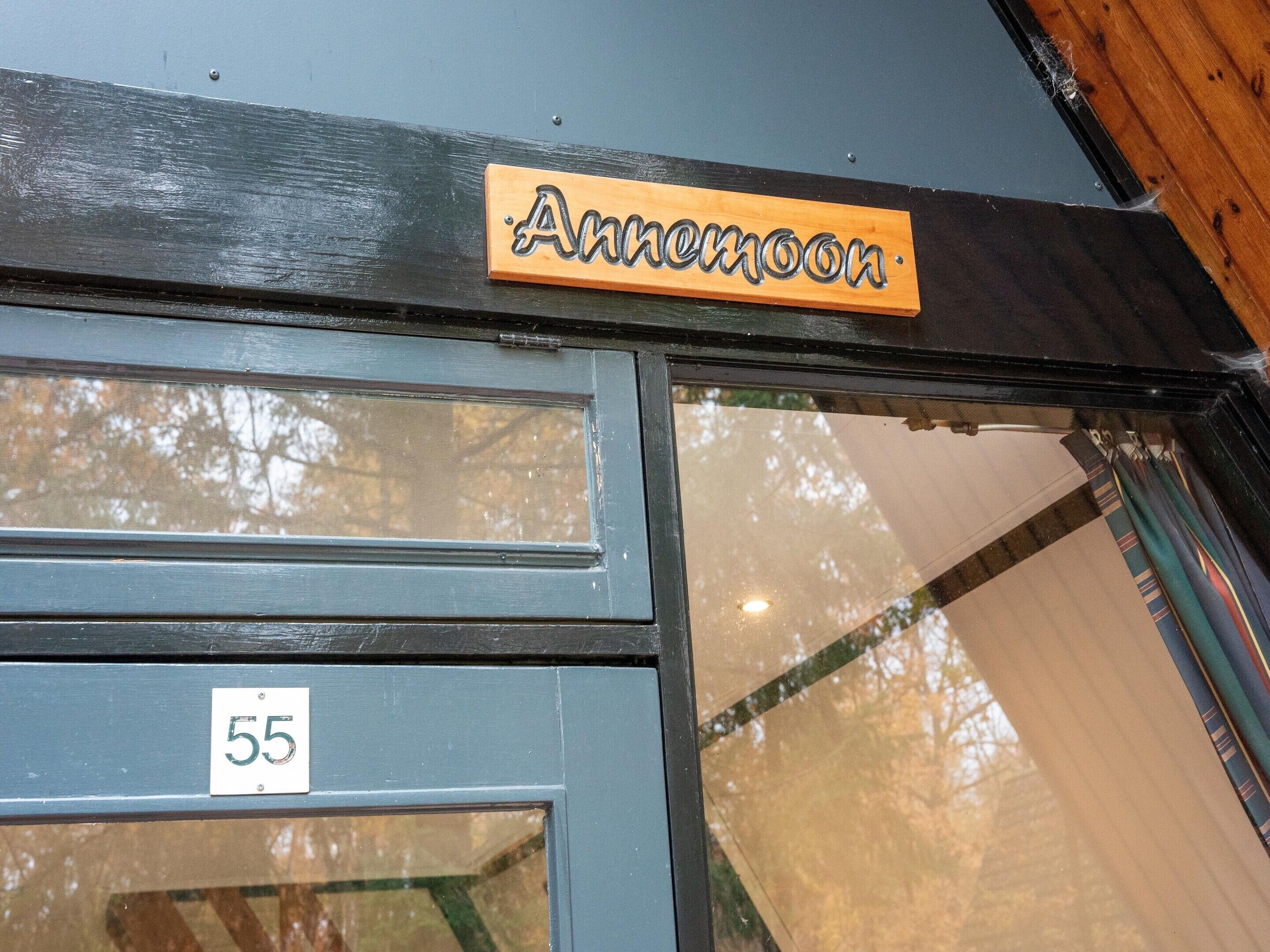 Une entrée d’immeuble avec une enseigne indiquant « Annemoon » et une porte portant le numéro « 55 ».