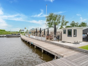 A dock extending into a body of water with a small building and a covered seating area. - Relaxing Holiday Chalet by the Water in Grou (Grou)