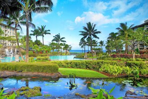 Relax by the serene pool surrounded by lush tropical vegetation and enjoy ocean views from the resort's multi-story buildings.