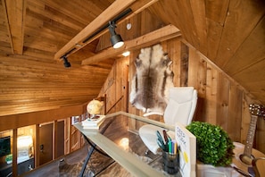 A wooden interior with a desk, a fur rug, a guitar, and a globe. - Sleeps 28, 2 Cabins, 10BR/8BA, Hot Tub, Game Room, Firepit, King Beds, Helen, GA (Sautee Nacoochee)