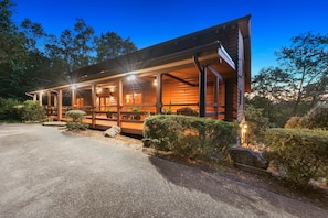 A wooden cabin with a porch, a driveway, and surrounding greenery. - Sleeps 28, 2 Cabins, 10BR/8BA, Hot Tub, Game Room, Firepit, King Beds, Helen, GA (Sautee Nacoochee)