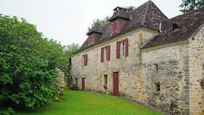 A stone building with red shutters and a sloped roof. - Authentic 19th c Farmhouse  with heated pool fiber optic and air conditionné (Saint-Germain-des-Prés)
