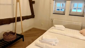 A room with a bed, a wooden ladder, a radiator, and two windows. - Cottage in Ubachsberg With Scenic Hills (Voerendaal)