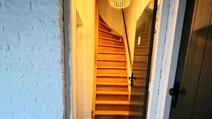 A staircase leading to a door with a wooden handrail and a light fixture above. - Cottage in Ubachsberg With Scenic Hills (Voerendaal)