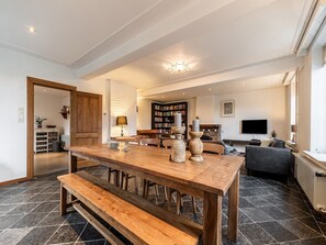 Relax in this inviting living area with a large dining table, comfortable seating, and a cozy sofa.