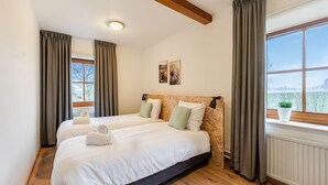 A double bed with a wooden headboard, two pillows, and a bedside lamp. - Holiday Home in South Limburg With a Terrace (Klimmen)
