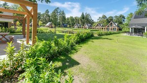 A residential area with multiple houses, a wooden pergola, and a grassy lawn. - Holiday Home in Lochem With Garden View (Lochem)