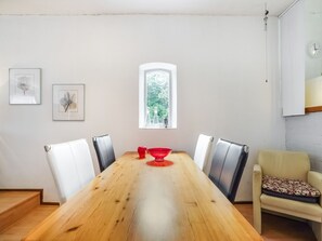 A dining area with a wooden table, four chairs, a red bowl, and framed artwork on the wall. - Bungalow in Landgraaf With Terrace (Landgraaf)