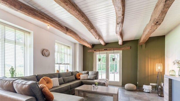 A spacious living room with a sectional sofa, a coffee table, and a fireplace. - Farmhouse in the Achterhoek With hot tub and Beach Volleyball (Megchelen)