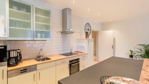 A modern kitchen with white cabinets, a stainless steel sink, a coffee maker, and a built-in oven. - Farmhouse in the Achterhoek With hot tub and Beach Volleyball (Megchelen)