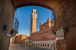 A historic building with a tall tower and a sign reading "Chiesso del Barcellio." - The Balcony Suite -Piazza del Campo View (Siena)