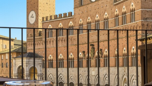 A historic building with arched windows and a clock tower. - The Balcony Suite -Piazza del Campo View (Siena)