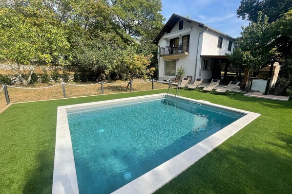 A rectangular swimming pool with a white border, surrounded by artificial grass. - Vacation home with private swimming pool (Grizane)