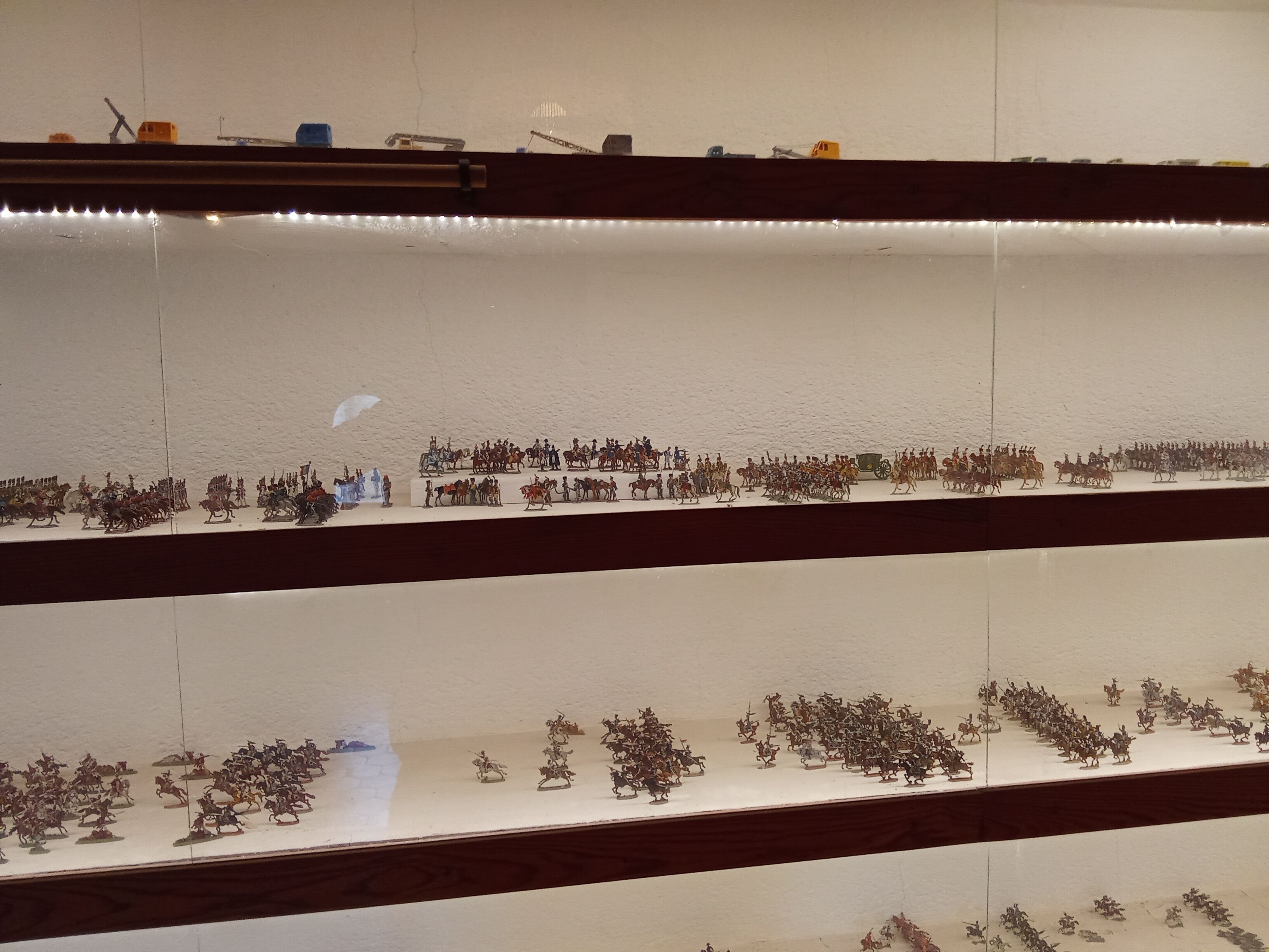 Une exposition de figurines miniatures disposées sur des étagères.