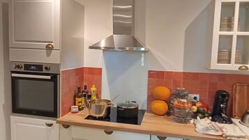 Een koelkast met diepvriezer, een microgolfoven, een oven, een kookplaat