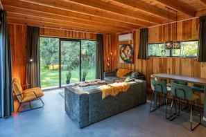Ein modernes Interieur mit einer Couch, einem Couchtisch und einer Bar mit Hockern.