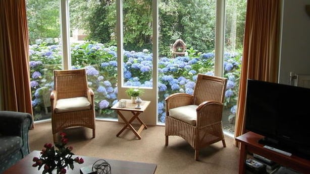 A room with two wicker chairs, a small table, and a television on a stand. - Holiday Home Buitenplaats Berg With 5 Rooms (Lemele)