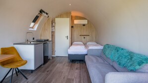 A compact room with a kitchenette, a bed, a sofa, and a small dining area. - Couple Retreat at Unique Nature Lodge (Dalerveen)