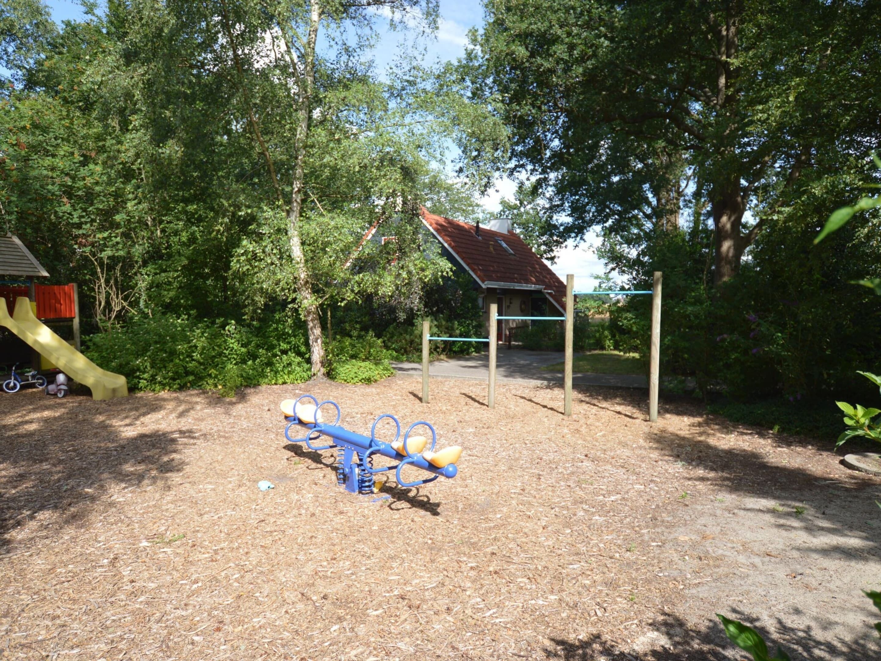 A playground with a seesaw, a slide, and a climbing structure.