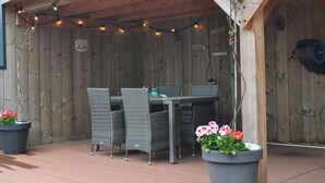An outdoor patio with wicker furniture and string lights. - Shed 57b in an old Flour Mill in Haulerwijk (Haulerwijk)