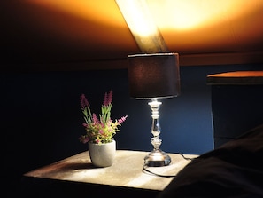 A bedside table with a lamp and a potted plant. - Shed 57b in an old Flour Mill in Haulerwijk (Haulerwijk)