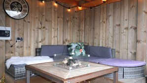 A wooden deck with a glass-top table, a sofa, and a loveseat. - Shed 57b in an old Flour Mill in Haulerwijk (Haulerwijk)