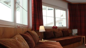 A cozy room with two wooden beds, a lamp, and a window with curtains. - Summer dream vacation apartment in the Zillertal with magnificent views (Schwendau)