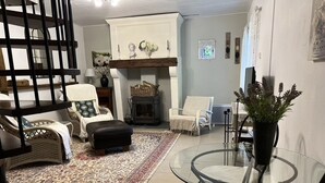 A living room with a fireplace, a glass table, and a variety of seating options including a sofa and armchairs. - La Chenaie ( 2C ) (Sorges et Ligueux en Périgord)