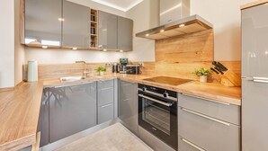 Een moderne keuken met roestvrijstalen apparatuur, houten aanrecht en een inbouwoven.