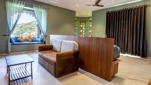 A cozy room with a sofa, a small table, and a wooden partition. - Rawla Sagrun (Kumbhalgarh)