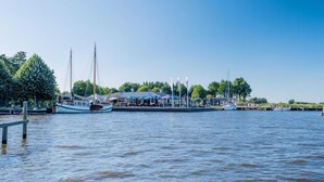 A marina with boats docked, a covered seating area, and a clear sky.