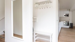 A modern kitchen with white cabinetry, a built-in oven, and a microwave.