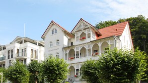 Ein weißes Gebäude mit bogenförmigen Balkonen und roten Ziegeldächern, mit der Aufschrift "Haus Eintracht".