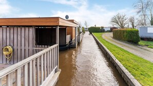 A narrow canal with a wooden structure on the left, a grassy area on the right, and a clear sky above. - Luxury Holiday Home in Bantega With Harbour and Sloop (Bantega)