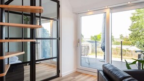 A modern interior with a sliding glass door leading to an outdoor patio area. - Apartment Near Sneekermeer Water Sports (Offingawier)
