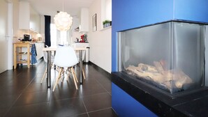 Una cocina moderna con comedor, chimenea y una pared azul decorativa.