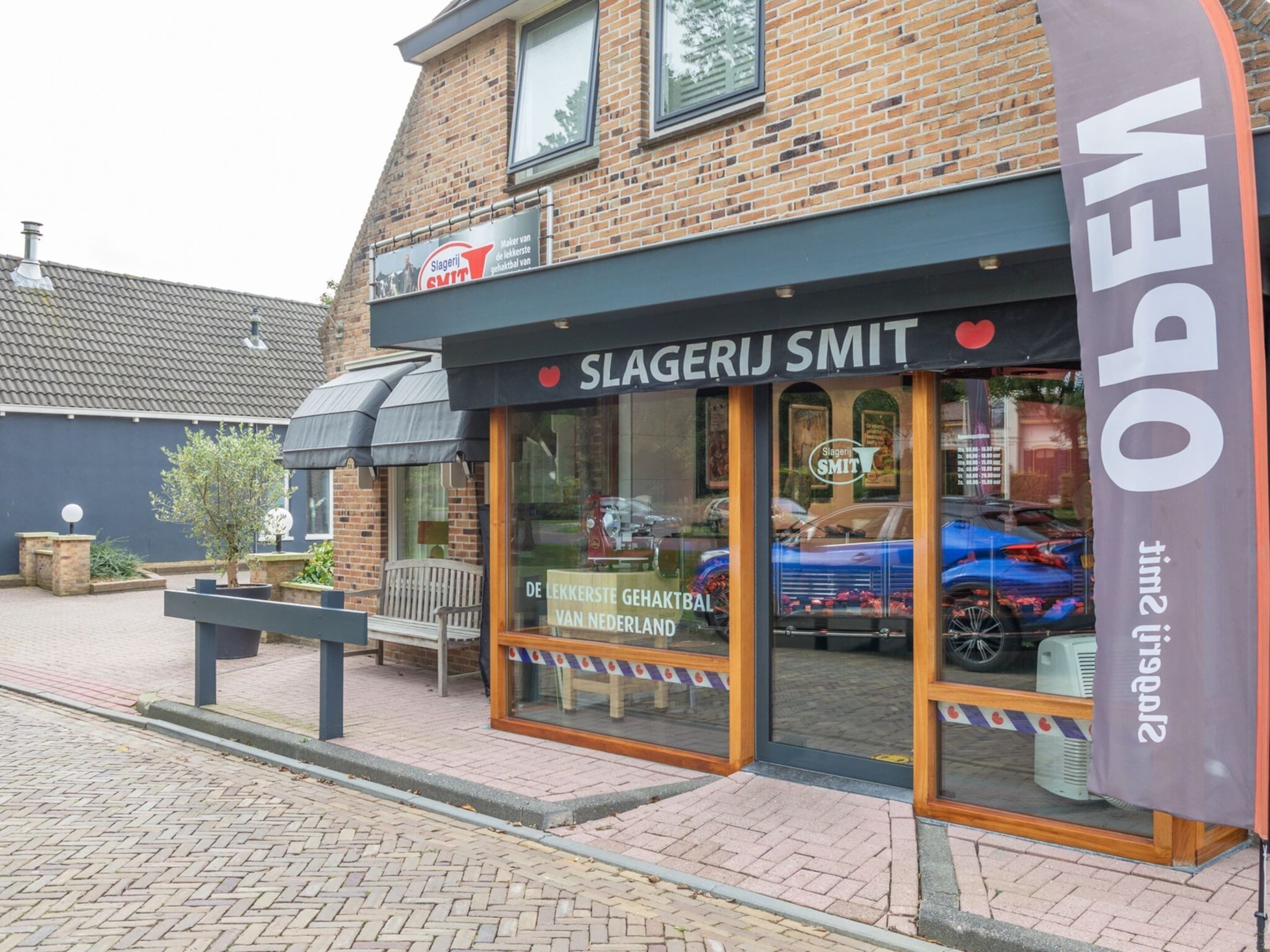 Un bâtiment en briques abritant un commerce de détail appelé « Slagerij Smit ».