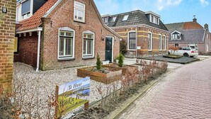 Een rij traditionele bakstenen huizen met puntige daken en witte luiken.