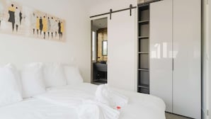 A modern bedroom with a large bed, a sliding closet door, and a wall-mounted artwork. - Holiday Home in Stavoren by Private Jetty (Stavoren)