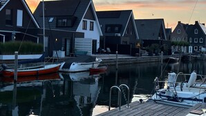 A waterfront property with a dock, boats, and traditional houses. - Holiday Home in Stavoren by Private Jetty (Stavoren)