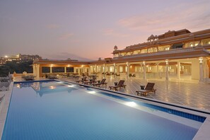 Une grande piscine intérieure dotée de chaises longues et d’un espace salon abrité.