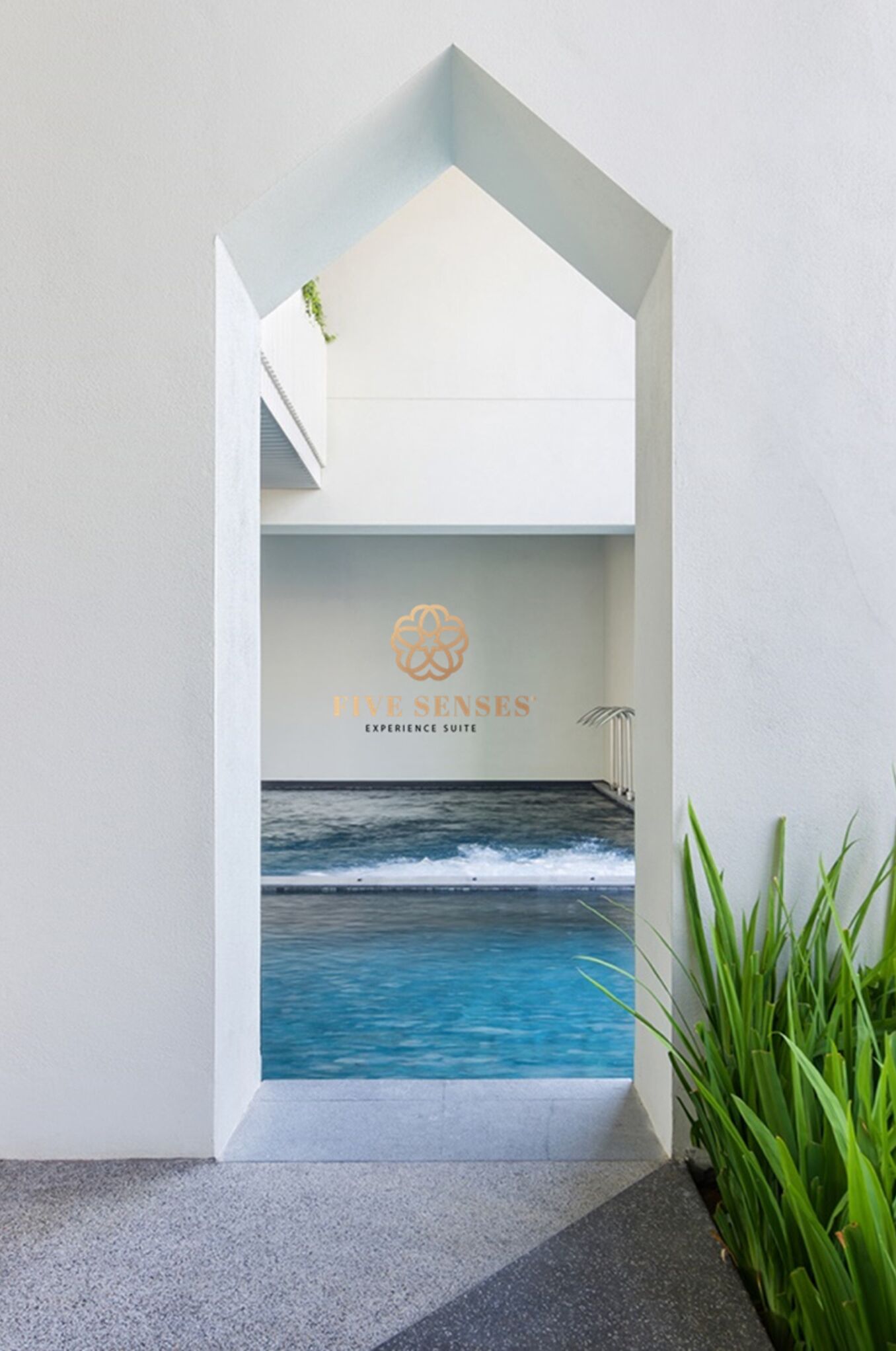 Interno moderno di un hotel con vista su una piscina e il logo di 'Five Senses Experience Suite'.